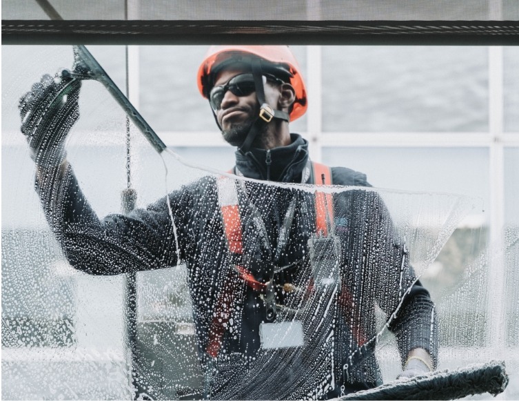 Agent de nettoyage nettoyant les vitres de locaux professionnels en Île de France